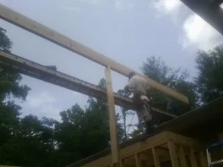 Carpenter setting a ridge beam over a new addition frame — Ice Dam Removal by Roofing Brothers in Escalante
