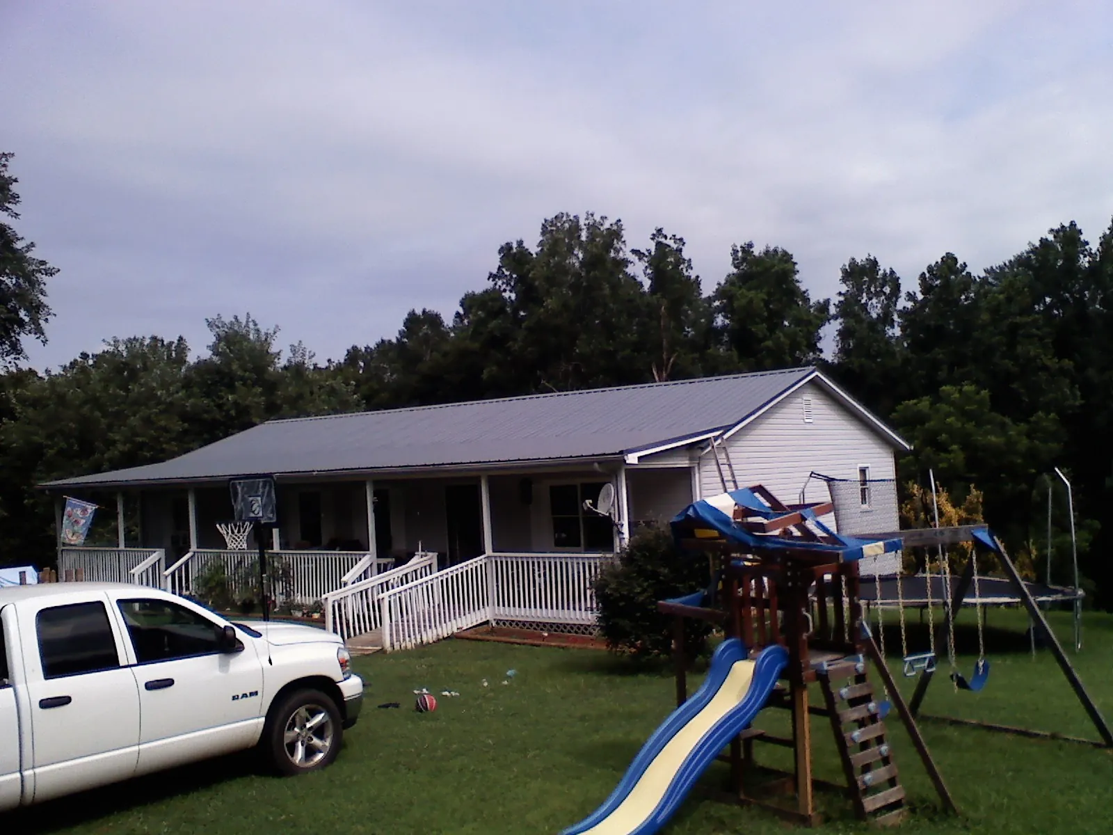 Dark metal roof on a country home with a full length front porch in Escalante